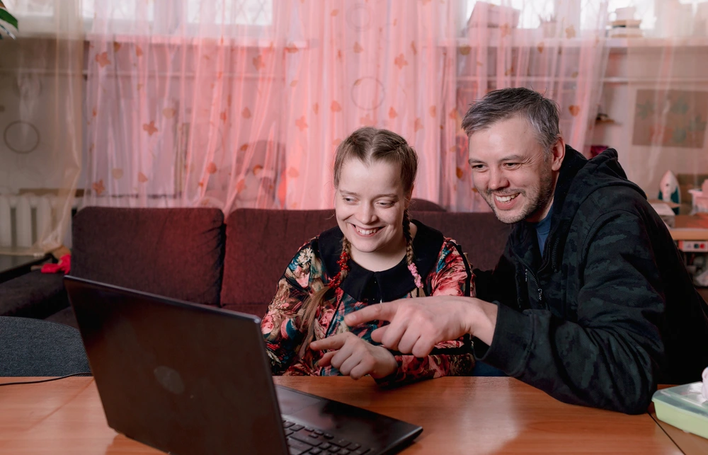 disabled girl watching movie with caretaker